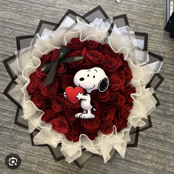 Bouquet of red roses with a Snoopy heart topper and black ribbon