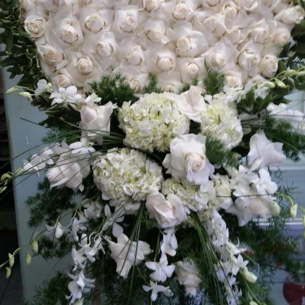 Large white rose and hydrangea standing spray with green foliage
