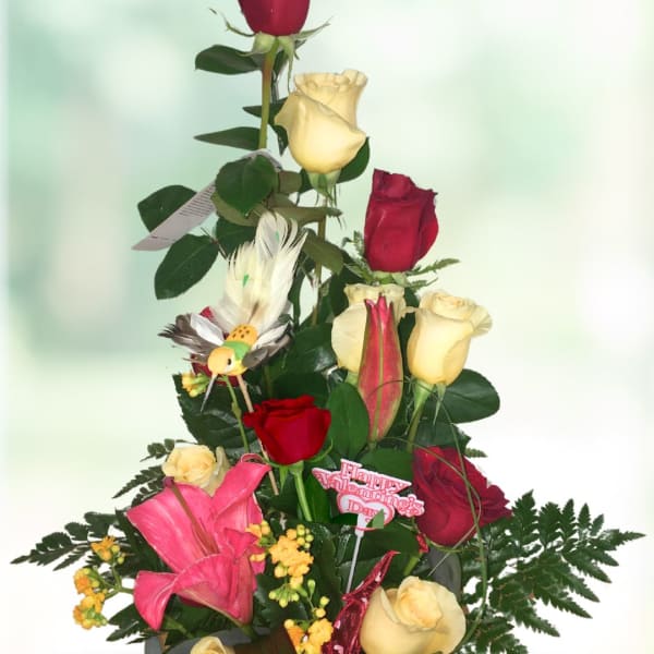 Tall bouquet of red and yellow roses with pink lilies and a Valentine pick