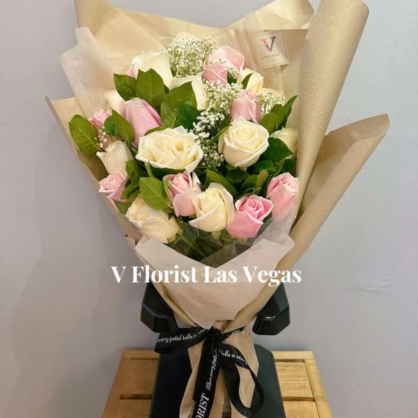 Bouquet of pink and white roses wrapped in beige paper