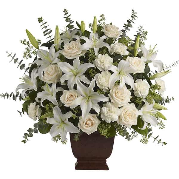 White lilies and cream roses arranged in a brown urn vase