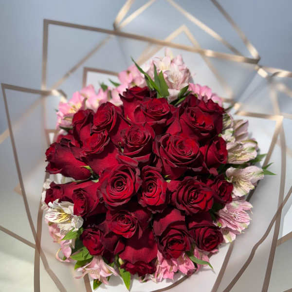 Bouquet of red roses with pink flowers wrapped in clear paper