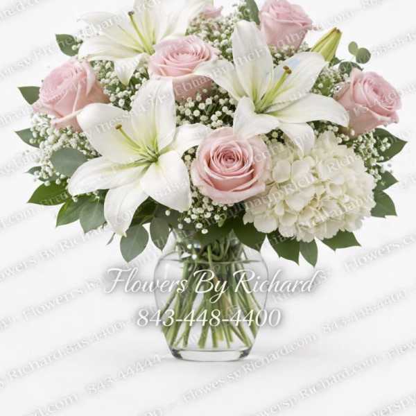 Pink roses and white lilies in a clear glass vase