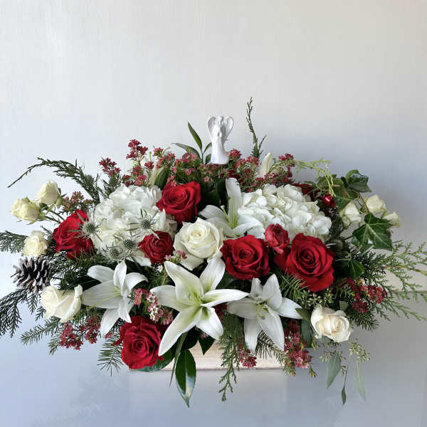 Red and white rose arrangement with lilies and hydrangeas in a low container