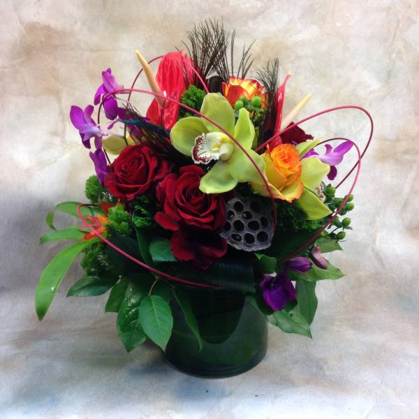 Colorful bouquet of roses and orchids in a dark vase