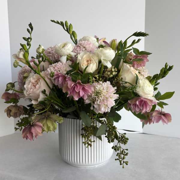 Pink and white floral arrangement in a ribbed white vase