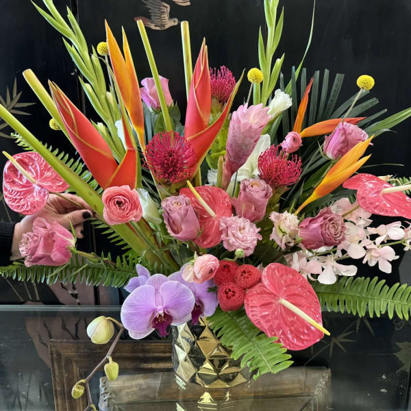 Tropical bouquet with orchids, anthuriums, and bird-of-paradise in a gold vase