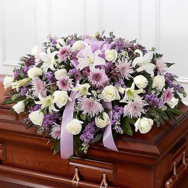 Casket spray with white and lavender flowers and ribbon