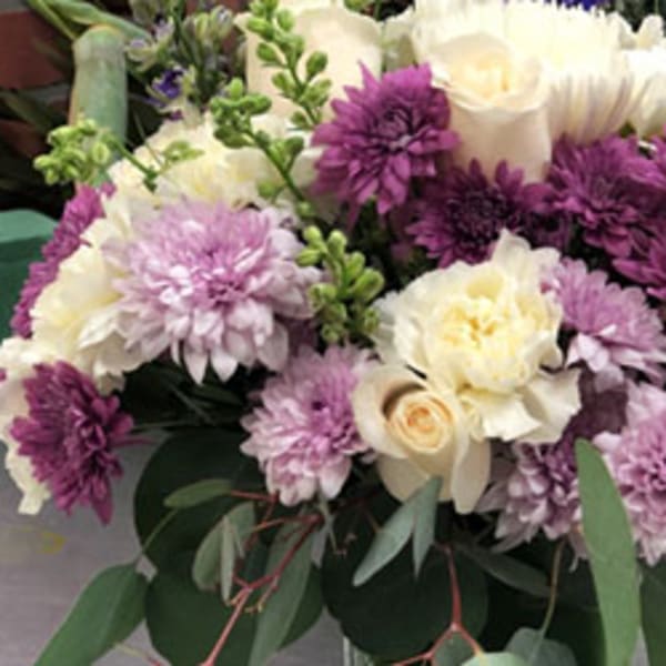 Bouquet of purple and cream flowers with greenery