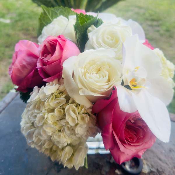 Bouquet of pink and white roses with a pale hydrangea cluster