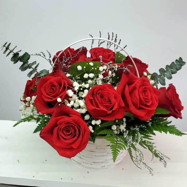 Basket arrangement of red roses with baby's breath and greenery