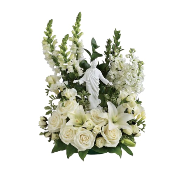 White floral arrangement with a small religious statue in the center