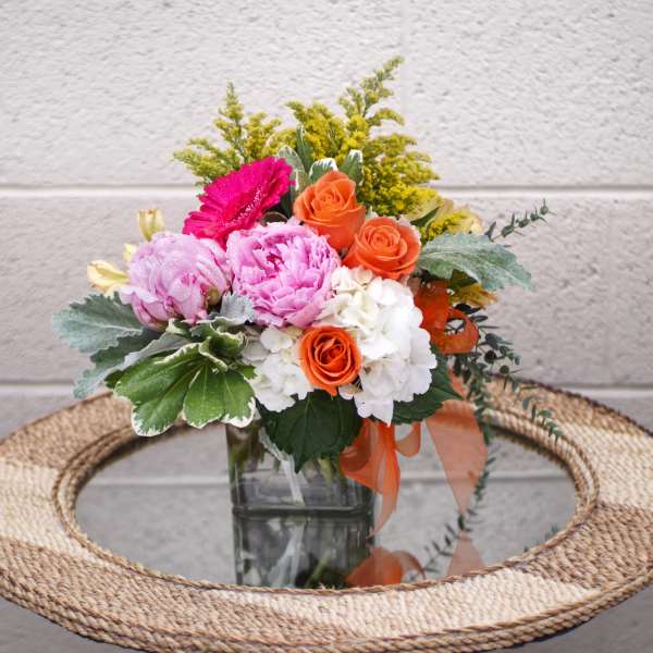 Mixed bouquet in a glass vase with pink, orange, and white flowers
