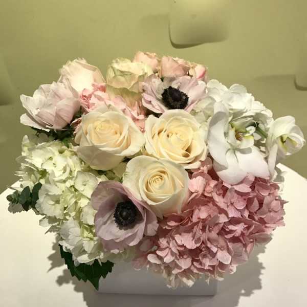 Pastel bouquet of roses, hydrangeas, and anemones in a white box