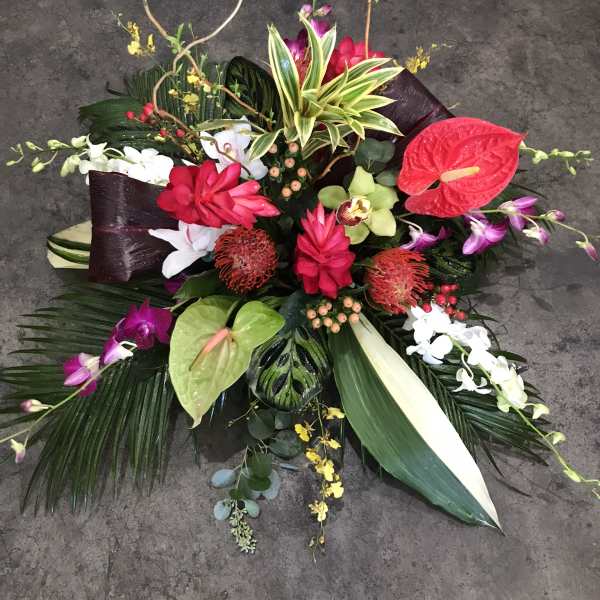 Tropical floral arrangement with anthuriums, orchids, and red blooms