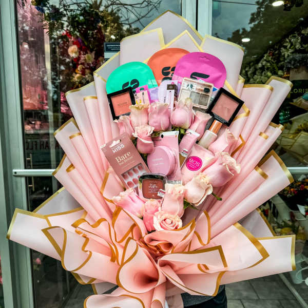 Pink rose bouquet with makeup and cosmetics wrapped in pale pink paper
