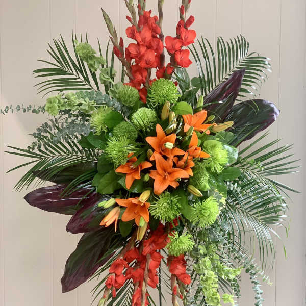 Tall tropical floral arrangement with orange lilies and red gladiolus