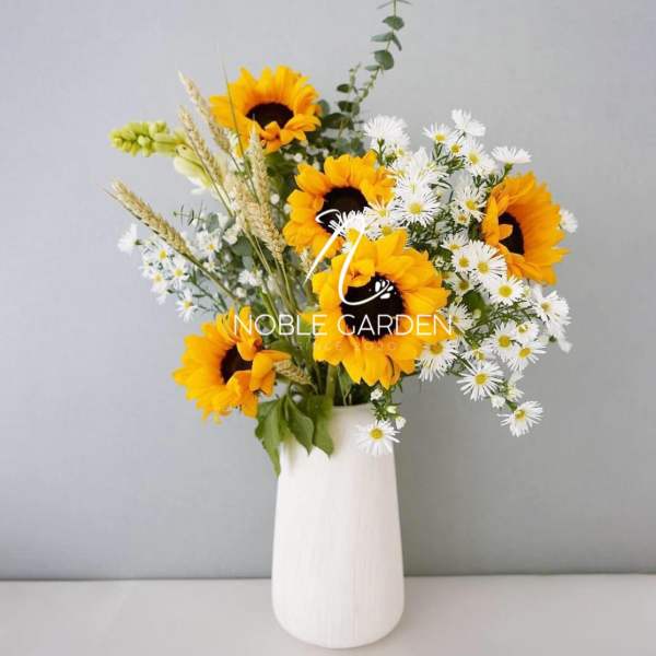 Sunflowers and white daisies in a white vase