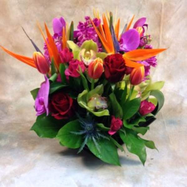 Bright tropical bouquet with orange bird of paradise and purple flowers