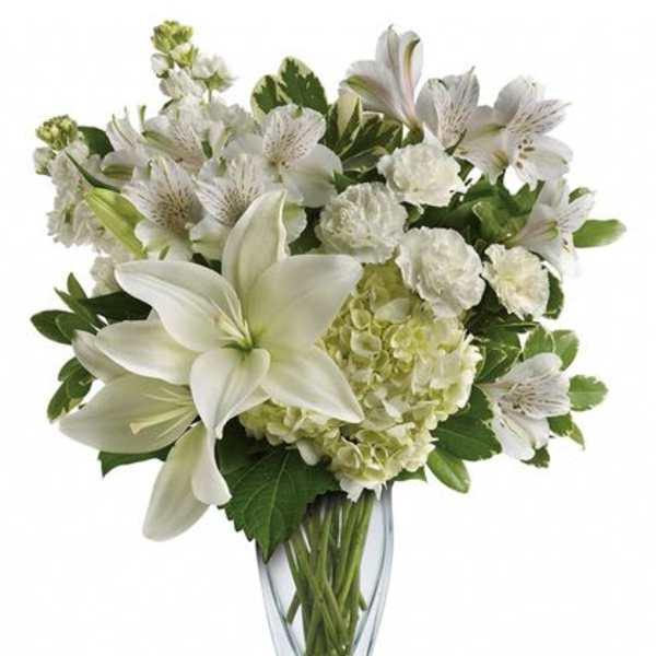 White lilies and alstroemeria in a clear glass vase