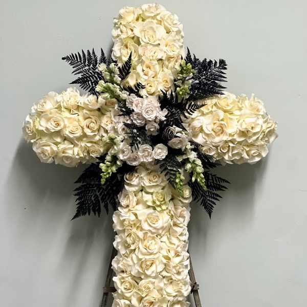 White rose cross-shaped floral tribute on an easel