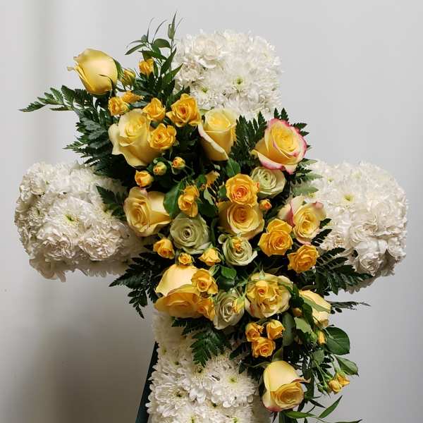 Cross-shaped floral spray with yellow roses and white chrysanthemums