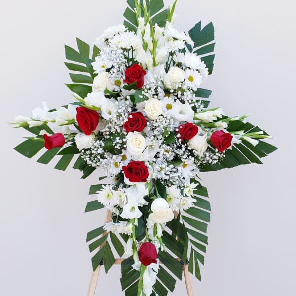 Standing floral cross with red and white roses and daisies