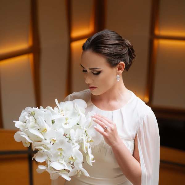 Bride holding a large white orchid bouquet