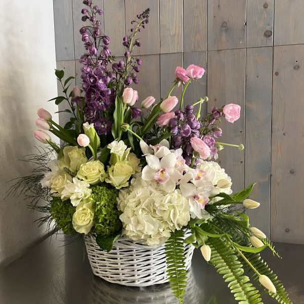 Basket arrangement of pink, white, and purple flowers