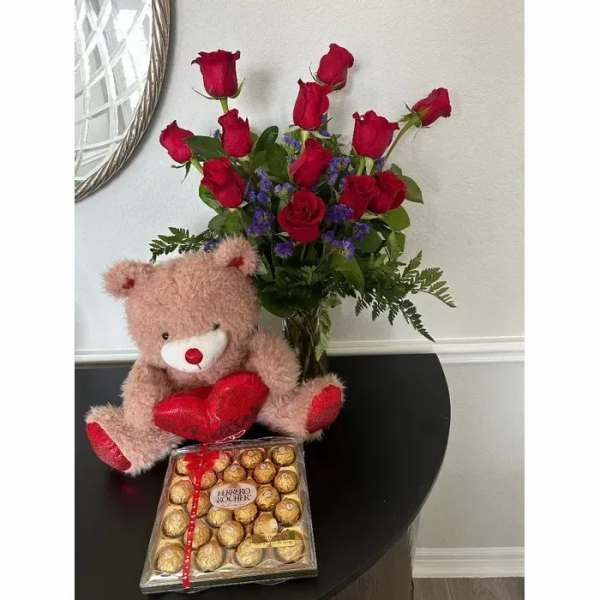 Bouquet of red roses with a teddy bear and chocolate box