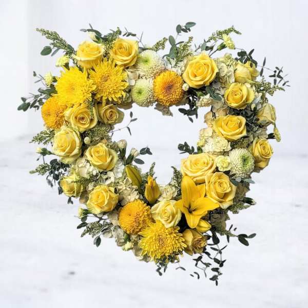 Heart-shaped yellow floral arrangement with roses and mums