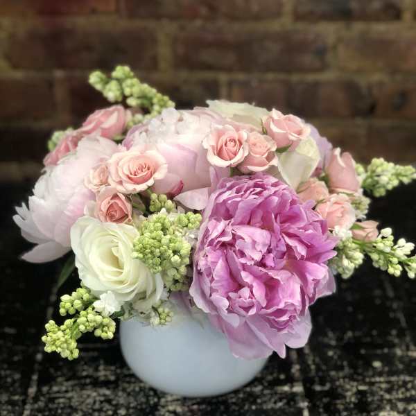 Pink and white floral arrangement in a white vase