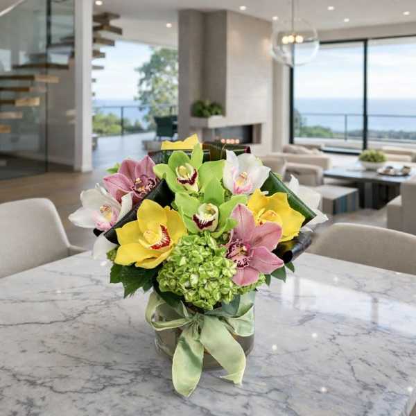 Bouquet of orchids in a glass vase with a green ribbon