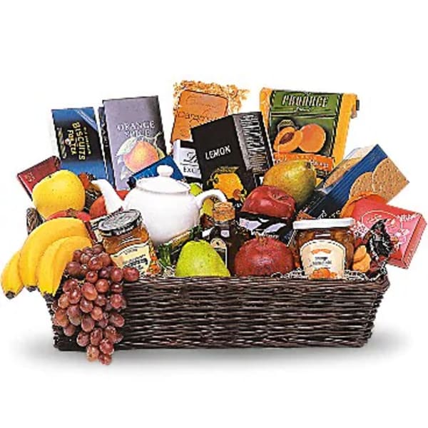 Gift basket with fruit, tea, and snacks in a wicker tray