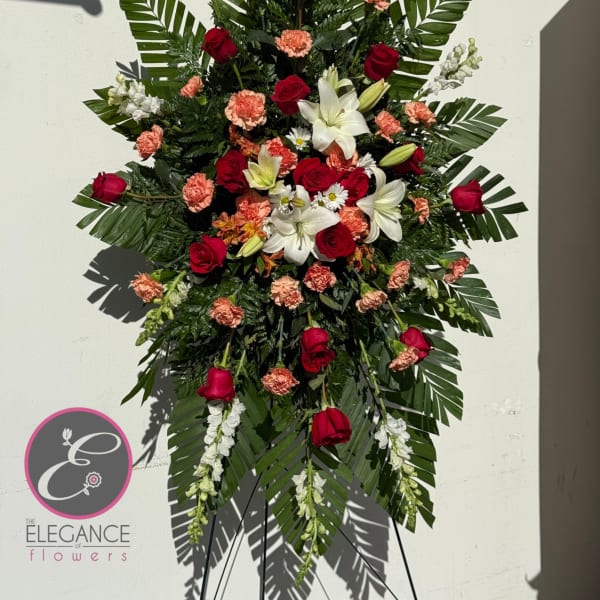 Standing floral spray with red roses, white lilies, and peach carnations