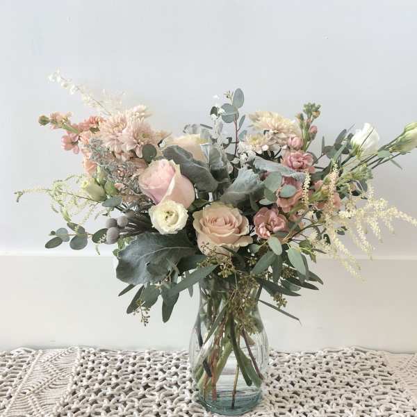 Blush and white flower bouquet in a clear glass vase