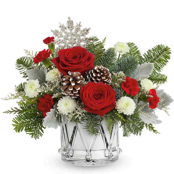 Red roses and white mums in a clear glass vase with pinecones