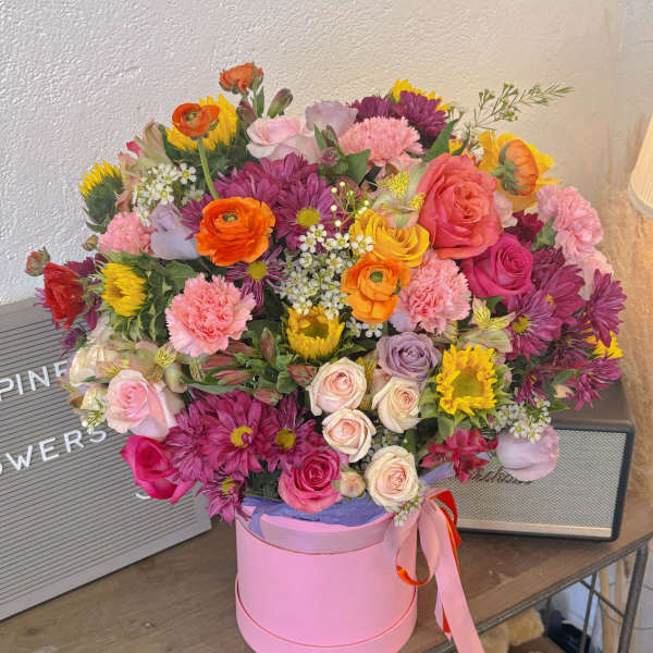 Mixed bouquet in a pink hat box with roses and daisies