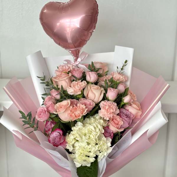 Pink bouquet with roses, carnations, hydrangea, and a heart balloon