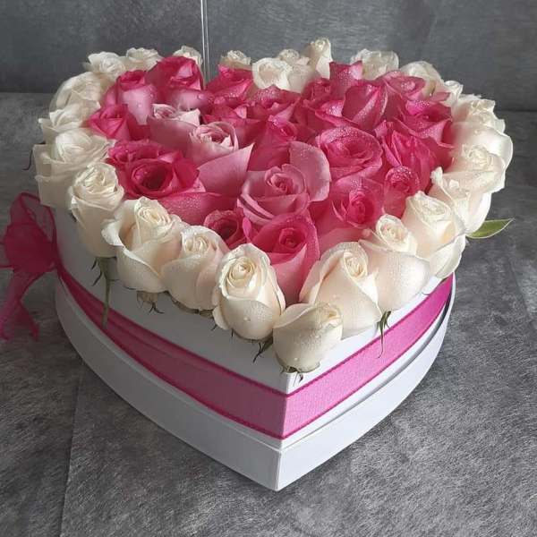 Heart-shaped box filled with pink and white roses