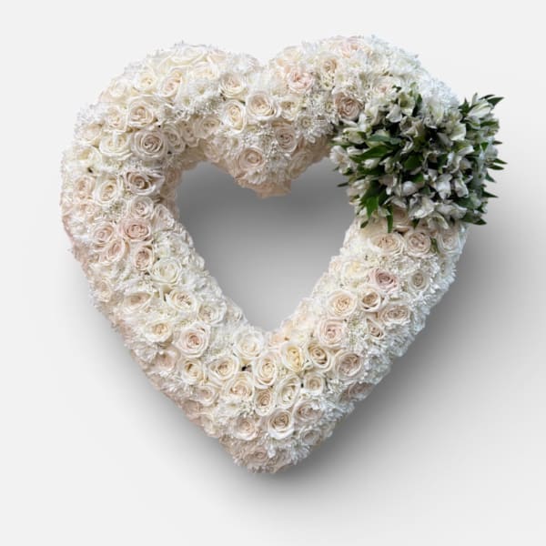 Heart-shaped floral wreath of white roses and pale blooms