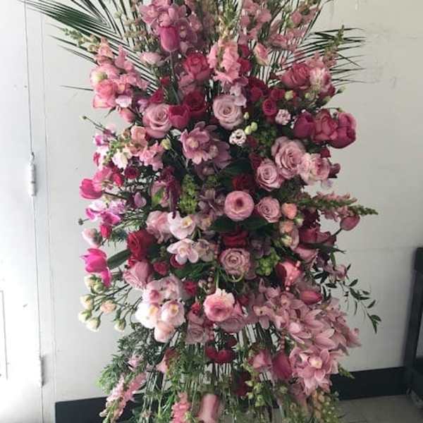 Tall pink floral standing spray with roses and orchids
