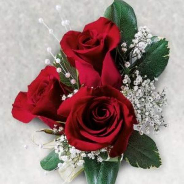 Three red roses with baby's breath and greenery