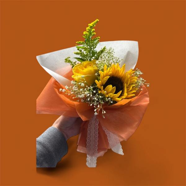Handheld bouquet with a sunflower and yellow rose wrapped in orange paper