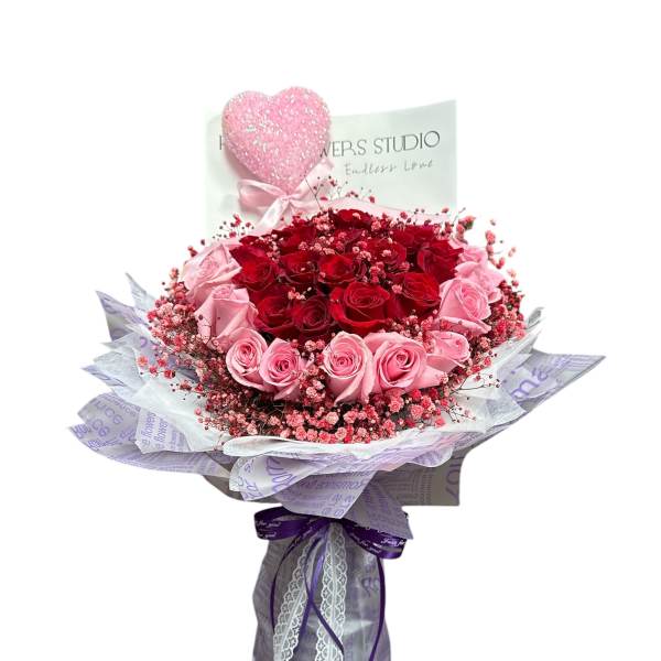 Bouquet of red and pink roses with a glittery heart topper
