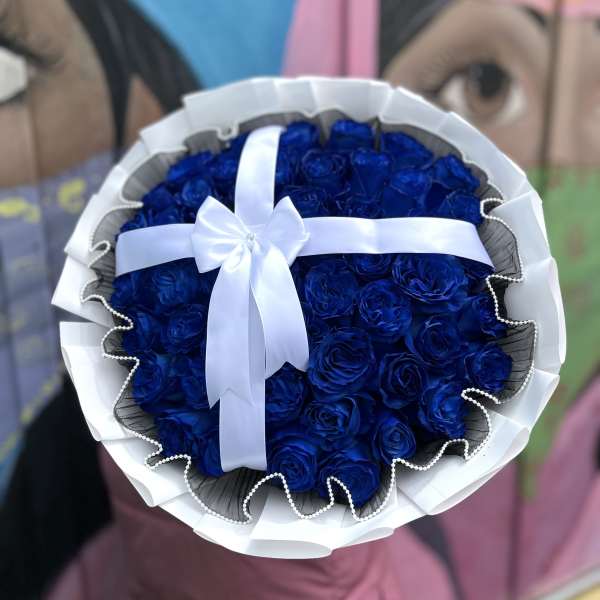Bouquet of deep blue roses wrapped with white ribbon