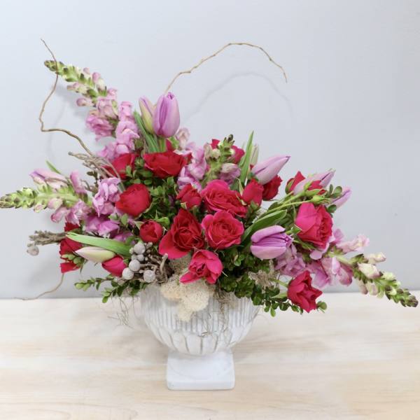 Pink and red floral arrangement in a white vase