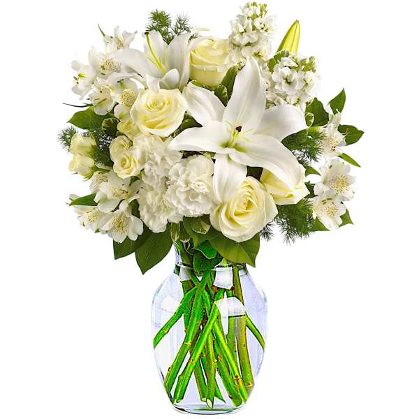 White lilies and roses arranged in a clear glass vase