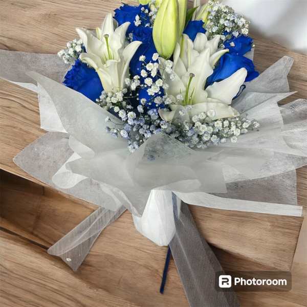 Bouquet of white lilies and blue roses wrapped in white paper