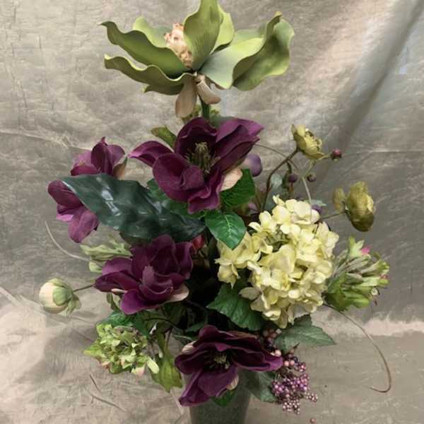 Purple and cream floral arrangement in a dark vase